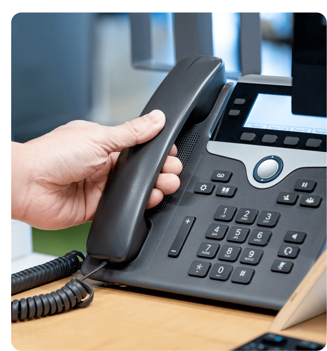 Hand lifting receiver of office phone.